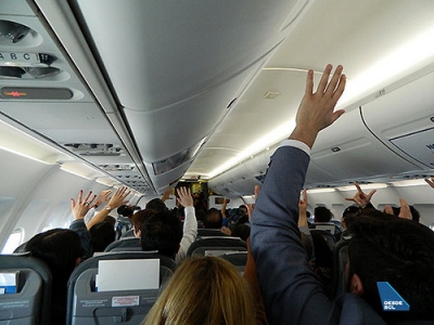 SKY pasajeros avión manos alzadas.