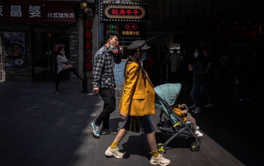 Gente camina en un &aacute;rea de compras en Wuhan.