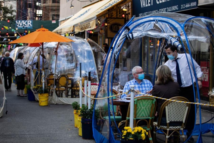 Clientes de una cafeter&iacute;a de Nueva York, protegidos por una burbuja de pl&aacute;stico.