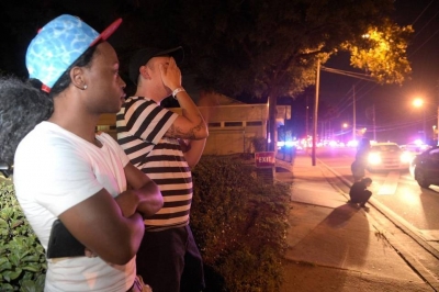 Jermaine Towns, izquierda, y Brandon Shuford esperan en la calle tras un tiroteo múltiple en un club nocturno en Orlando