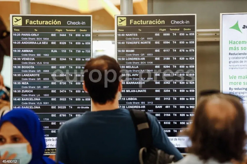 Pasajeros observan las pantallas con los vuelos de la Terminal 4 del Aeropuerto Adolfo Su&aacute;rez Madrid Barajas, a 1 de julio de 2022, en Madrid (Espa&ntilde;a).