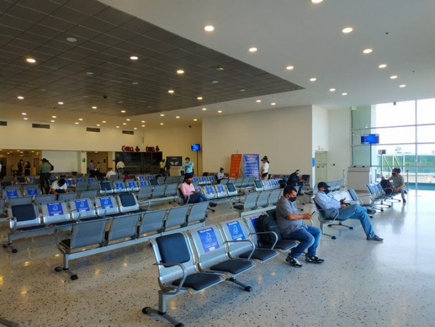 Los pasajeros esperando abordar el avi&oacute;n y respetando la distancia.