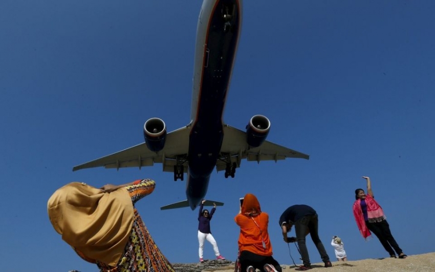 Varios turistas sac&aacute;ndose fotos en la playa Mai Khao, aeropuerto internacional de Phuket en Tailandia.