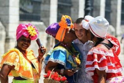 Un turista ruso se toma fotos con mujeres cubanas, este mi&eacute;rcoles, en la Plaza de Armas de La Habana.