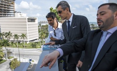 Giovanni Caloretti, ejecutivo de ventas de Douglas Elliman, explica cómo será el complejo de Park Grove en Miami, Florida, a José Parada (izq.) y su agente de propiedades, Sergio Cesario (centro).