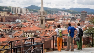 Turistas en Bilbao disfrutan de una panor&aacute;mica de la Villa en la que sobresale a torre de la Catedral de Santiago en del Casco Viejo.