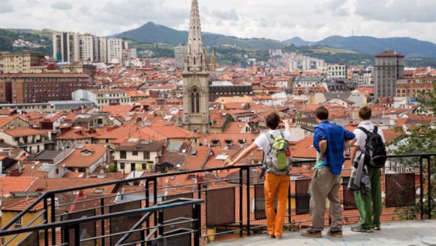 Turistas en Bilbao disfrutan de una panor&aacute;mica de la Villa en la que sobresale a torre de la Catedral de Santiago en del Casco Viejo.