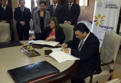 Carlos Pereira, del BNF, aparece firmando el acuerdo. A su lado, la ministra de Turismo, Marcela Bacigalupo.