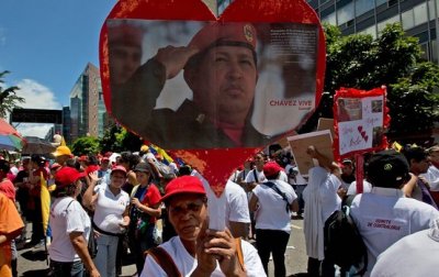 Una partidaria del presidente Nicol&aacute;s Maduro sostiene una foto de Hugo Ch&aacute;vez durante una marcha. 