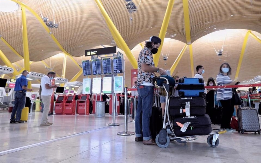 El levantamiento de las restricciones viajeras incrementa un 76% las b&uacute;squedas de seguros de viaje Archivo - Varias personas con equipaje hacen cola, durante el d&iacute;a en el que se pone en marcha el certificado COVID Digital para garantizar la movilidad segura ante la COVID19, en la T4 del aeropuerto Adolfo Su&aacute;rez, Madrid-Barajas, 1 de julio de 2021