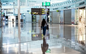 Una pasajera camina sola en la zona comercial de El Prat