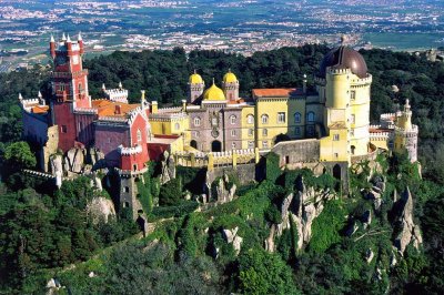 La ciudad de Sintra está toda engalanada de mansiones y palacios -como el de Pena- edificados por los muchos reyes, aristócratas, millonarios y artistas que a lo largo de su historia cayeron rendidos ante la belleza de este paraje natural, descolgado por una frondosa sierra de granito surcada de precipicios y manantiales. Retiro predilecto de los monarcas portugueses, el conjunto de Sintra, ciudad, sierra y paisajes está declarado Patrimonio de la Humanidad por la Unesco.