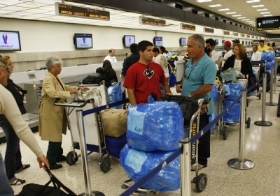 Un grupo de pasajeros espera para documentar su equipaje en un vuelo charter de Miami a Holgu&iacute;n en abril del 2009.