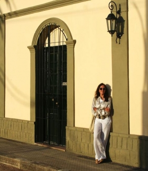 Nuestra corresponsal con el fondo de la Casa de la Cultura del pueblo