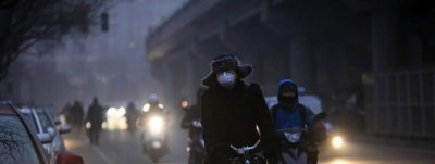 Un ciclista utiliza una mascarilla mientras circula en bici por una calle de Pek&iacute;n (China) por la contaminaci&oacute;n que envuelve la ciudad How Hwee Young 