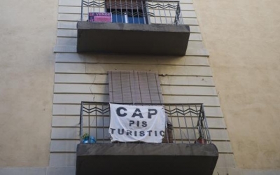 Un cartel contra los pisos tur&iacute;sticos, en uno de los barrios m&aacute;s afectados de la ciudad.